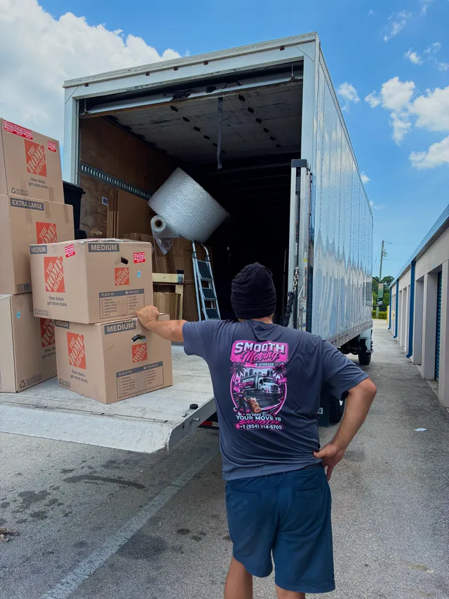Mover stacking boxes at the tailgate of the truck