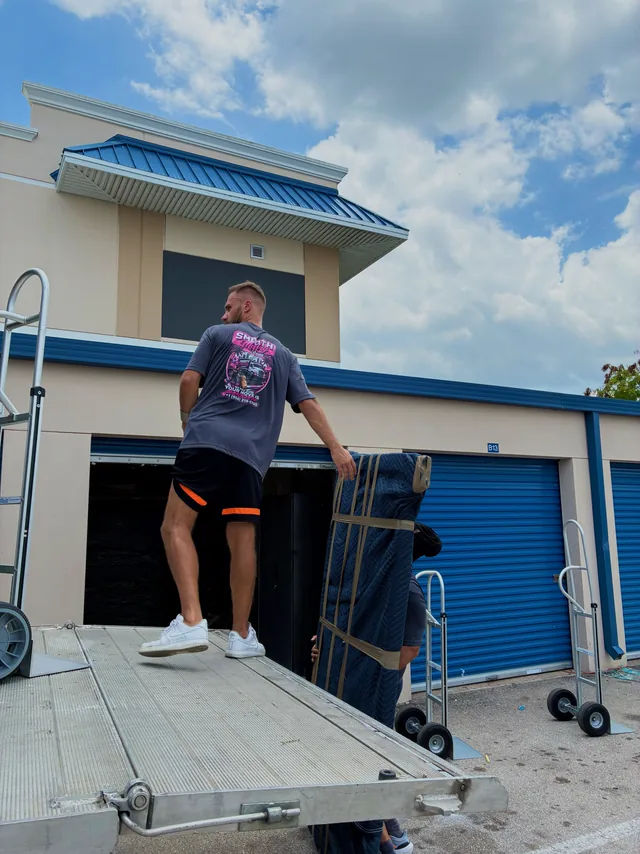 Mover wheeling a loaded dolly up the truck ramp
