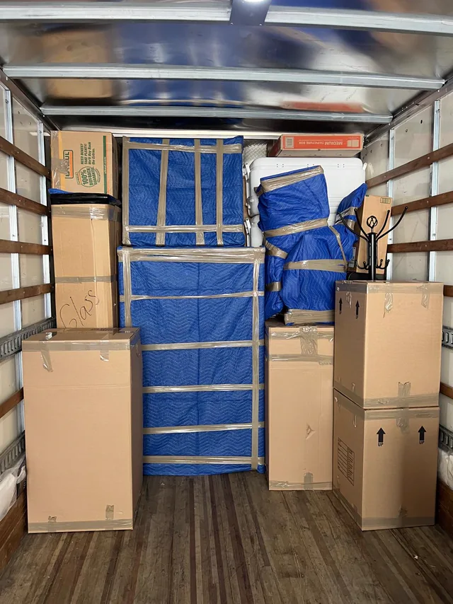 Truck loaded wall to wall with boxes and blanket-wrapped furniture